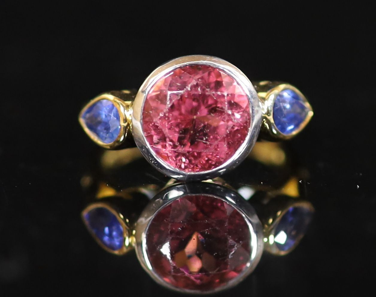 A Theo Fennell 18ct gold, collet set single stone pink tourmaline and two stone pear shaped sapphire set dress ring